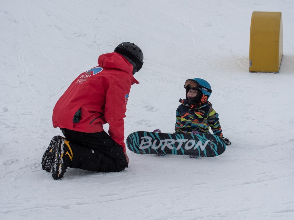 Kid and instructor in snowboard gear