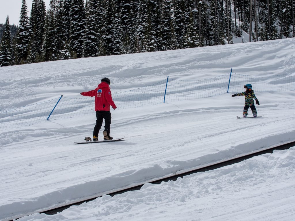 Kid and instructor snowboarding