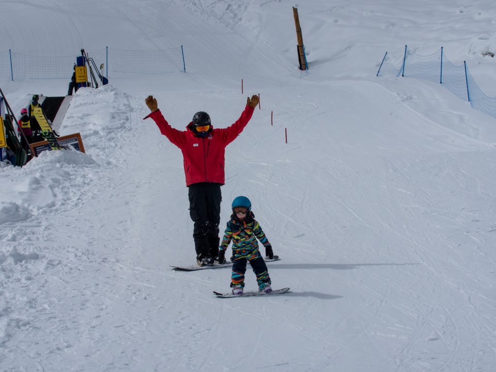 Kid and snowboard instructor
