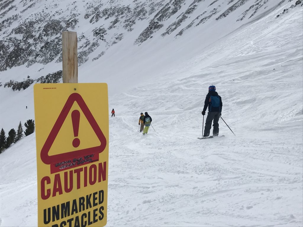 Skiers crossing the Turkey Traverse with a caution sign in front